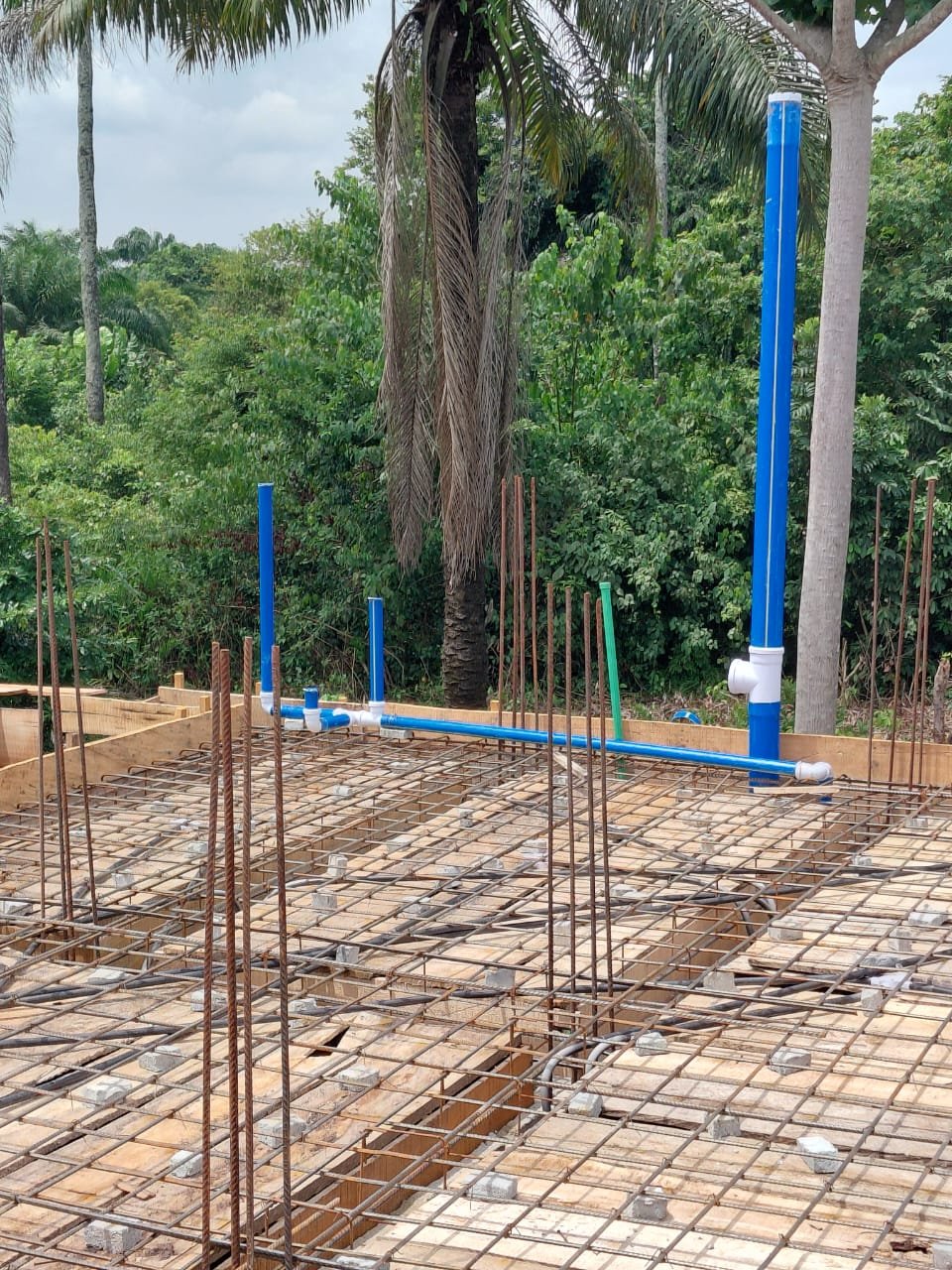 Reinforced concrete foundation slab with plumbing stub-outs on site